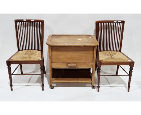 Mid-century oak sewing cabinet trolley, the hinged lid opening to fabric lined interior, with drawer and shelf below, on cast