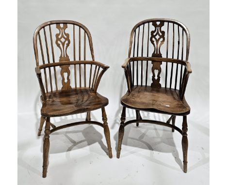 Two similar elm seated and ash Windsor hoop and comb-back elbow chairs, each with shaped pierced splat, saddle seat, on turne