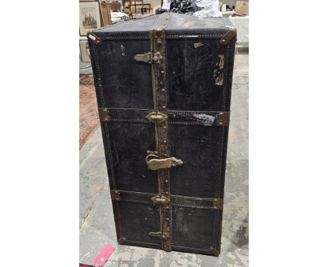 Early 20th century metal bound travelling wardrobe trunk, with leather handles, opening to an interior folding hanging rail (