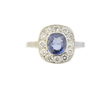 A sapphire and diamond cluster ring, the cushion shape sapphire weighing approx. 0.90ct within a brilliant cut diamond surrou