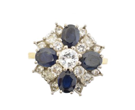 A sapphire and diamond cluster ring, the brilliant cut diamond within a similarly cut diamond and oval shape sapphire surroun