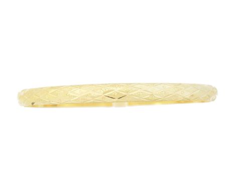 A bangle, with engraved and textured detailing, stamped 750, inner diameter 7cm, gross weight 12.4g.Condition report: Overall