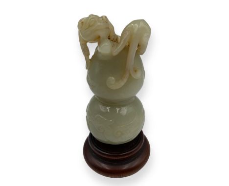 18th century Celadon Jade double gourd carved to the top with a coiled guei dragon, the body carved with a Pheonix amidst clo