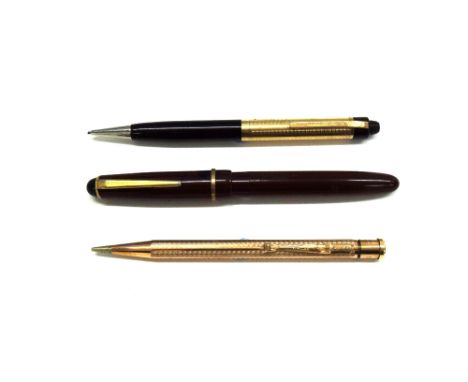 A Sheaffers propelling pencil in black and gilt, stamped 1/10 14k Y.G.F., in fitted case, a rolled gold yard-o-lead propellin