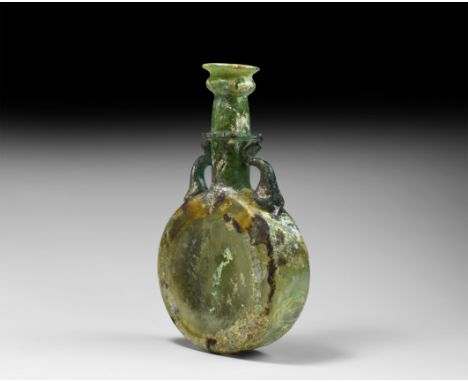 5th century AD. An iridescent aqua glass drum-shaped flask with applied trumpet-shaped rim to the neck, applied trail collar 