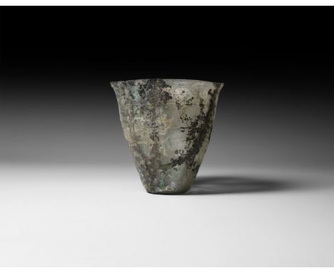 1st century AD. A conical clear glass cup with flared rim, circumferential incised bands, dimple to the base.   59 grams, 85m