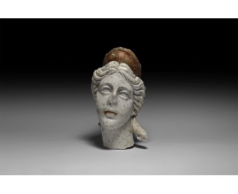 2nd-3rd century AD. A carved marble head of Venus(?) (Greek Aphrodite) with detailed chignon hairstyle drawn back from the fa
