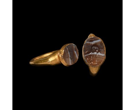 3rd-4th century AD. A hollow-formed gold hoop with expanding shoulders, raised oval bezel inset with agate gemstone (possibly