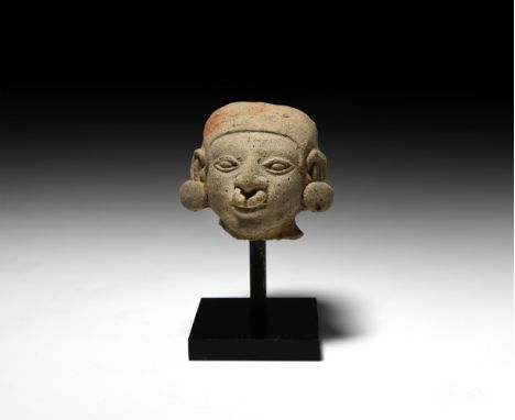 5th century BC-5th century AD. A ceramic male head with tight-fitting rolled headdress, large rings to the ears and nostrils;