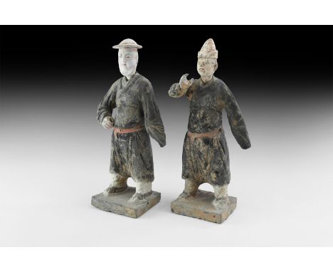 Ming Dynasty, 1368-1644 AD. A pair of painted ceramic figures with detachable heads, each wearing a belted wrap-over tunic an