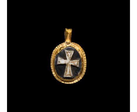 6th-7th century AD. A gold pendant with crimped rim, ribbed loop with granule, central cell with glass panel, high-relief exp