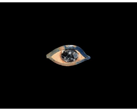 New Kingdom, 1550-1066 BC. An eye inlay from a mummy case, formed from a white glass panel with raised black glass pupil fitt