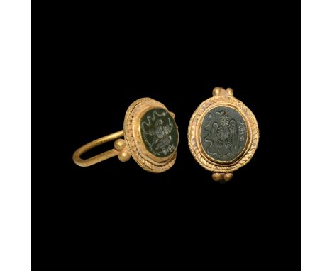 4th century AD. A gold finger ring with granules to the shoulders, disc plaque with applied filigree collar, cell with inset 