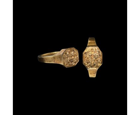 17th century AD. A silver-gilt ring with rectangular-section hoop expanding at the shoulders, octagonal bezel with a central 