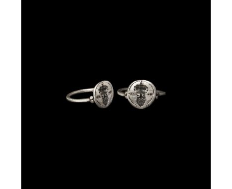 7th-13th century AD. A silver finger ring with plain hoop, granules to the shoulders, disc bezel with intaglio pelletted cros