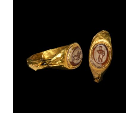 1st-2nd century AD. A hollow-formed gold finger ring with inset carnelian gemstone, intaglio gladiator with gladius drawn.   