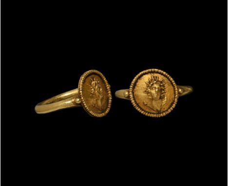 3rd-4th century AD. A gold finger ring with granule to each shoulder, beaded wire collar to the disc bezel with facing bust o