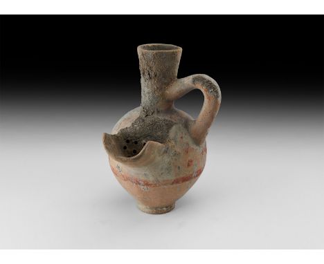 4th century BC. A ceramic beer or wine straining jug with tall everted spout, loop handle, strainer and pouring channel; pain