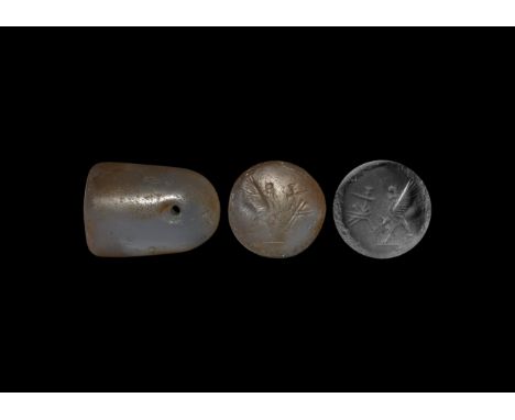 626-539 BC. A columnar agate stamp seal with intaglio rampant griffin on a baseline facing a short cuneiform inscription; acc