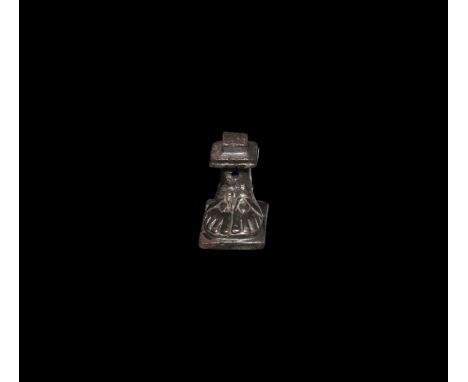 1st-2nd century AD. A silver base presenting a pair of feet, each foot sandalled, on a square panel, square shank above, holl
