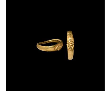 3rd century AD. A gold finger ring with applied granule cluster to the bezel and filigree hook below replicating a bunch of g