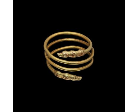 4th century BC. A substantial coiled gold 'arm ring' with terminals formed as stylised wolves, each with spiral hips and shou