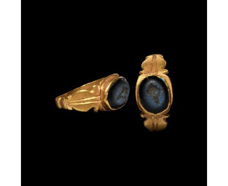 2nd century AD. A delicate gold ring with panels to the shoulders, the bezel a cell with inset nicolo gem, intaglio conch mot