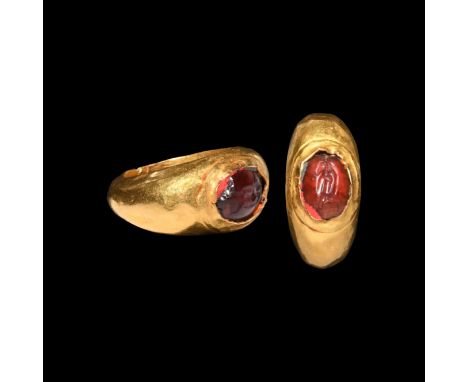 3rd century AD. A hollow-formed gold finger ring with inset carnelian gemstone, intaglio figure of Mercury(?) advancing with 