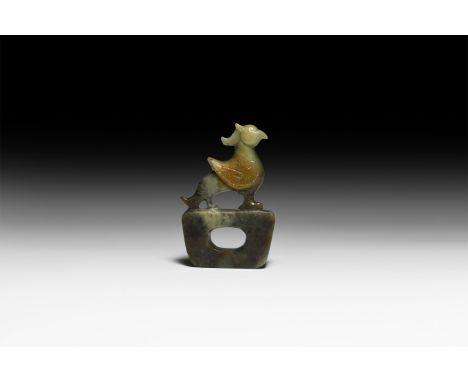 20th century AD. A carved jade amulet of a pieced trapezoidal base with fenghuang perched on the upper face, carved in the ro