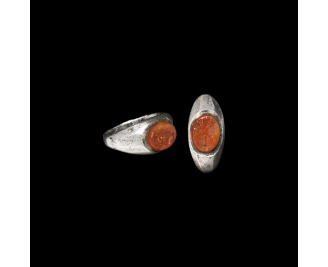 1st-2nd century AD. A silver finger ring with facetted shoulders, inset carnelian gemstone with intaglio winged figure holdin