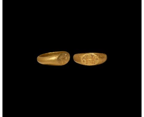 7th-8th century AD. A gold finger ring with ellipsoid plaque, monogram 'NBO?Y' flanked by a Maltese cross and starburst. 12.8