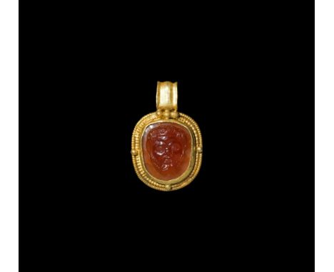 3rd century AD. A gold pendant with integral ribbed loop, applied granules to the plaque framed by concentric bands of beaded