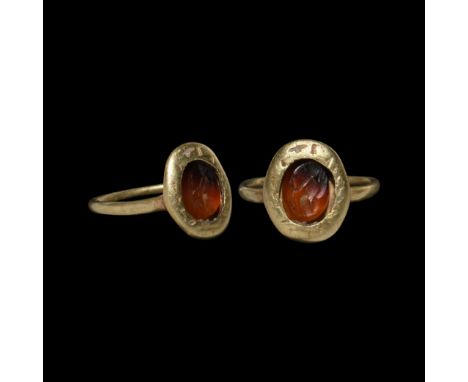 14th century AD. A gold finger ring with slender hoop, pie-dish bezel with broad rim, inset a Roman banded agate gemstone wit