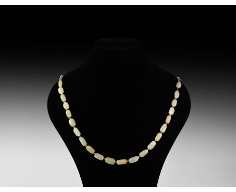 20th century AD. A Chinese necklace of milky jade fusiform beads with biconical spacers, modern clasp.   66 grams, 58cm (22 3