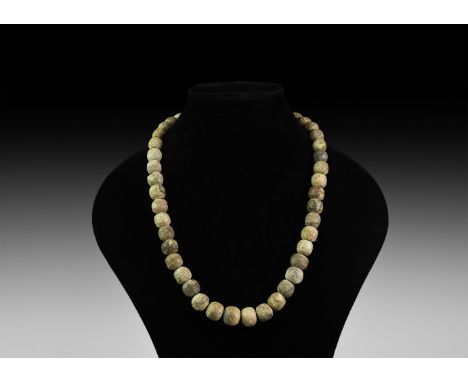 Devensian Period, 110,000-12,000 years BP. A restrung necklace string of carved fossilised mammoth bone oblate beads.   166 g