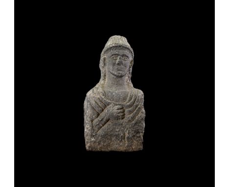 3rd-1st century BC. A life-size carved limestone bust on a cuboid block, hands clasped to the chest and draped cloak or tunic