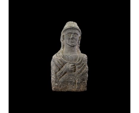 3rd-1st century BC. A life-size carved limestone bust on a cuboid block, hands clasped to the chest and draped cloak or tunic