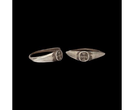11th-13th century AD. A silver ring with keeled hoop, angled shoulders and raised circular bezel with an engraved equal-armed