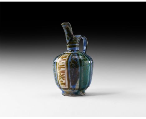 14th-16th century AD. A small ceramic ewer with body glazed in blue and green vertical panels incorporating three calligraphi