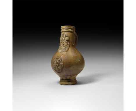 16th century AD. A salt-glazed stoneware jug of bartmannskrug type with bulbous body, narrow tiered base, ribbed collar and s