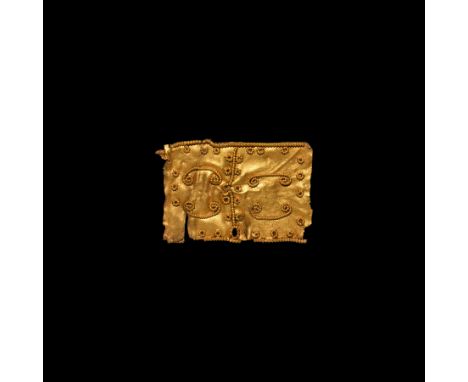 6th century AD. A flat gold plate with filigree ornamentation in the form of scrolls, rings and bands; pierced by a hole clos