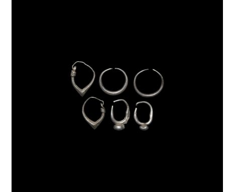 1st-3rd century AD. A group of silver hoop earrings comprising: a pair of penannular earrings; a pair of hoop earrings with a