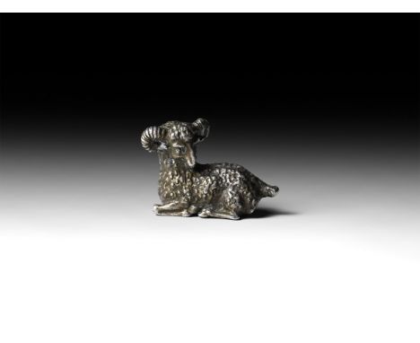 1st-2nd century AD. A silver figure of a ram laying with legs folded beneath the body and head turned to the rear.   36.9 gra