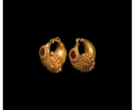 4th-5th century AD. A matched pair of hollow-formed gold boat-shaped earrings each with a panel of annulets and granulation t