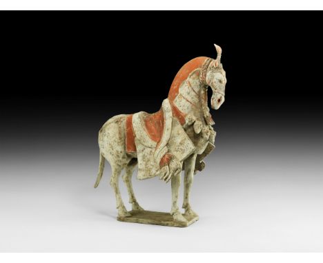 Northern Qi Dynasty, 549-577 AD. A ceramic figure of a horse in advancing pose with scarlet and maroon painted detailing, plu
