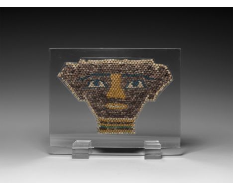 Ptolemaic Period, 332-30 BC. A restrung panel of small glazed composition beads in various colours, representing a mummy face