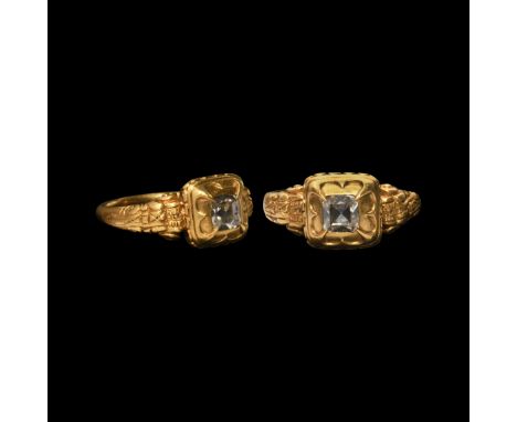 Early 17th century AD. A gold ring with D-section band flaring to ornamented and scrolled shoulders supporting a square cell 