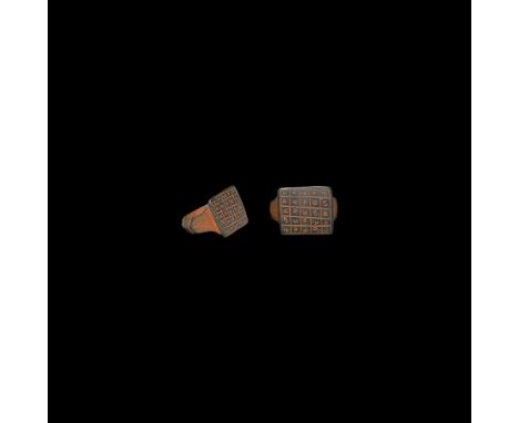 15th-16th century AD. A bronze ring with keeled hoop, expanding shoulders with chevron motifs; the square bezel divided into 
