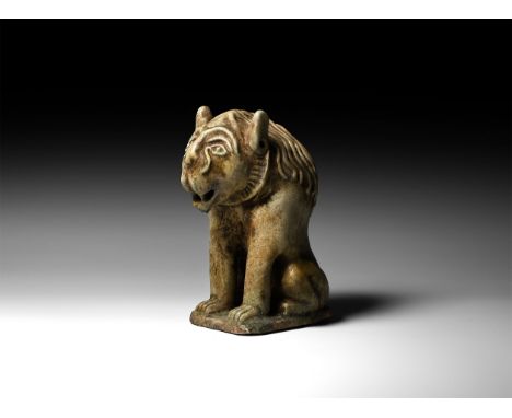 20th century AD or earlier. A glazed ceramic figure of a seated lion with heavy mane on rectangular base.   481 grams, 16cm (
