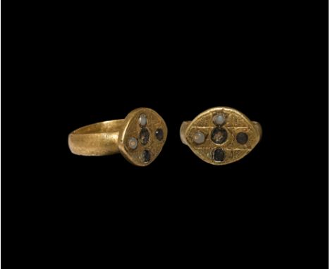 10th-12th century AD. A bronze D-section ring with raised lentoid bezel, the bezel with incised cross motif inset with glass 